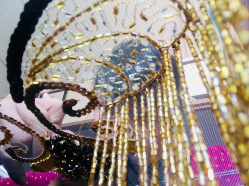 Bordado dorado con flecos y pedrería sobre tul oscuro