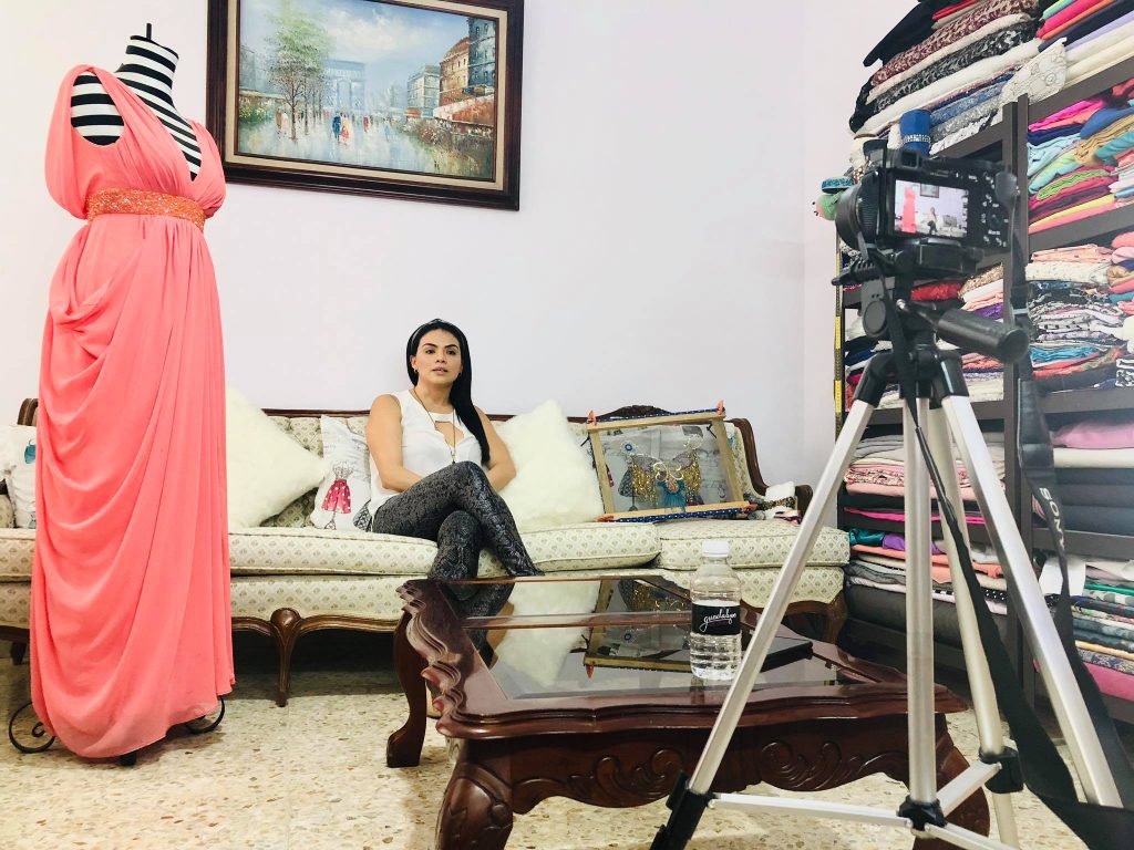 Guadalupe Ilescas en su estudio con un vestido rosa en exhibición