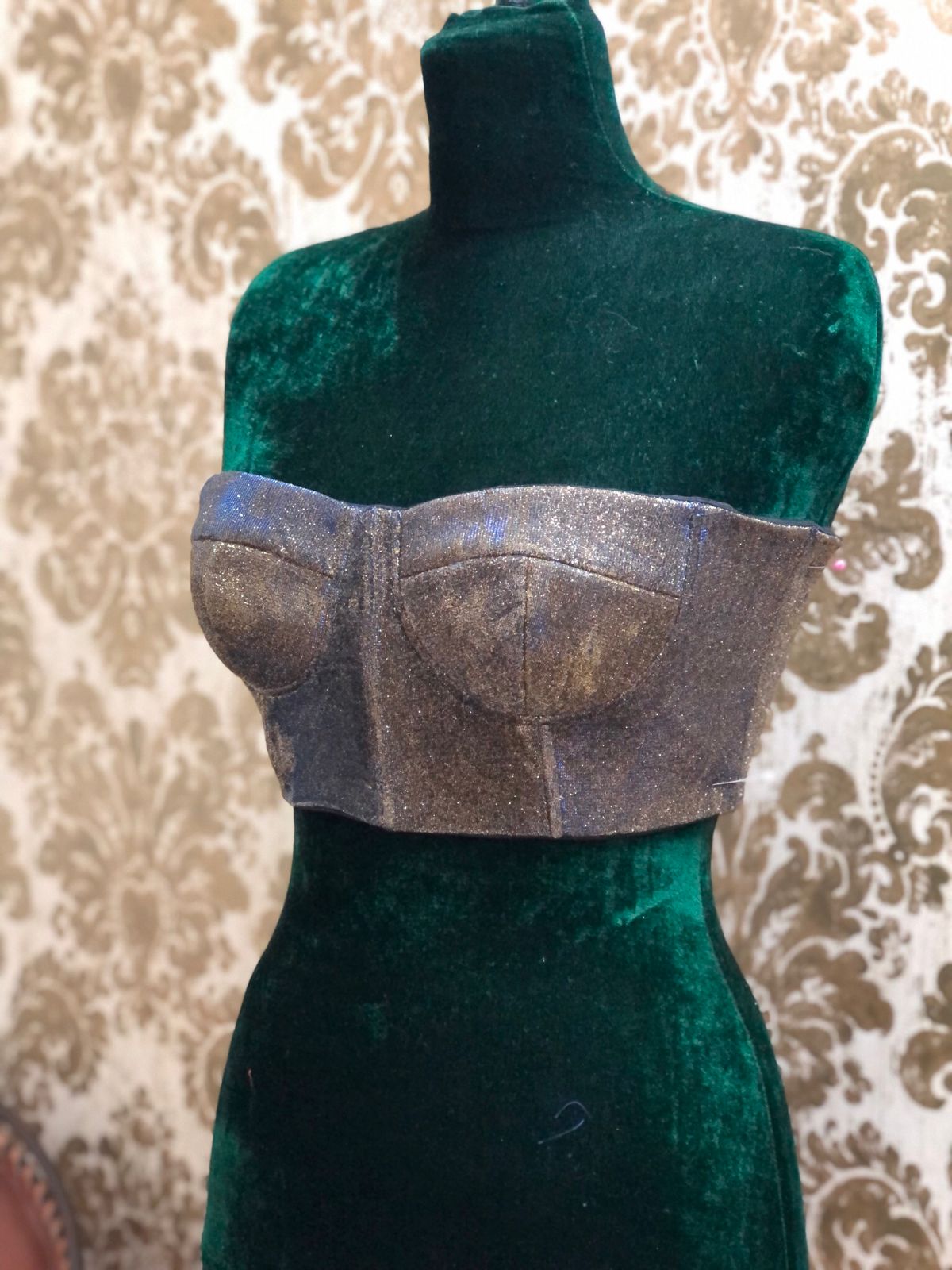 Bustier plateado sobre maniquí de terciopelo verde
