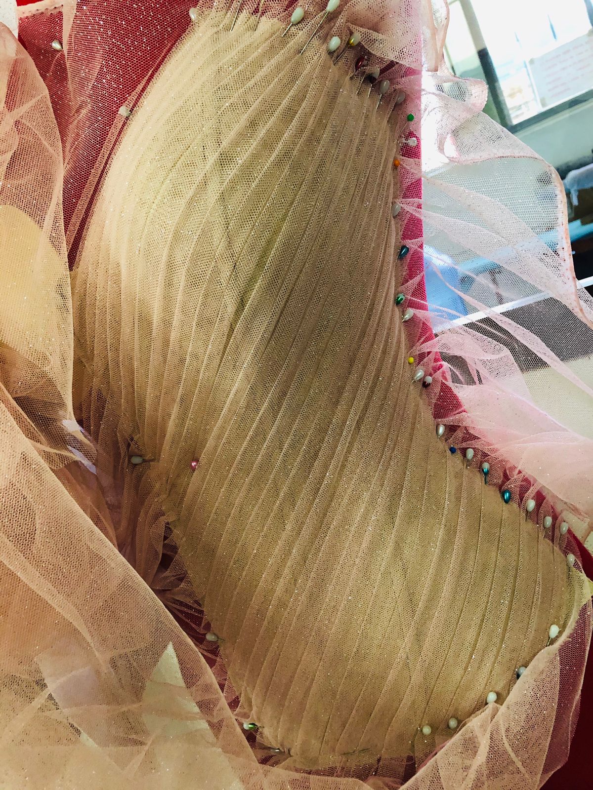 Detalle de drapeado en plisado color crema con orilla de pedrería