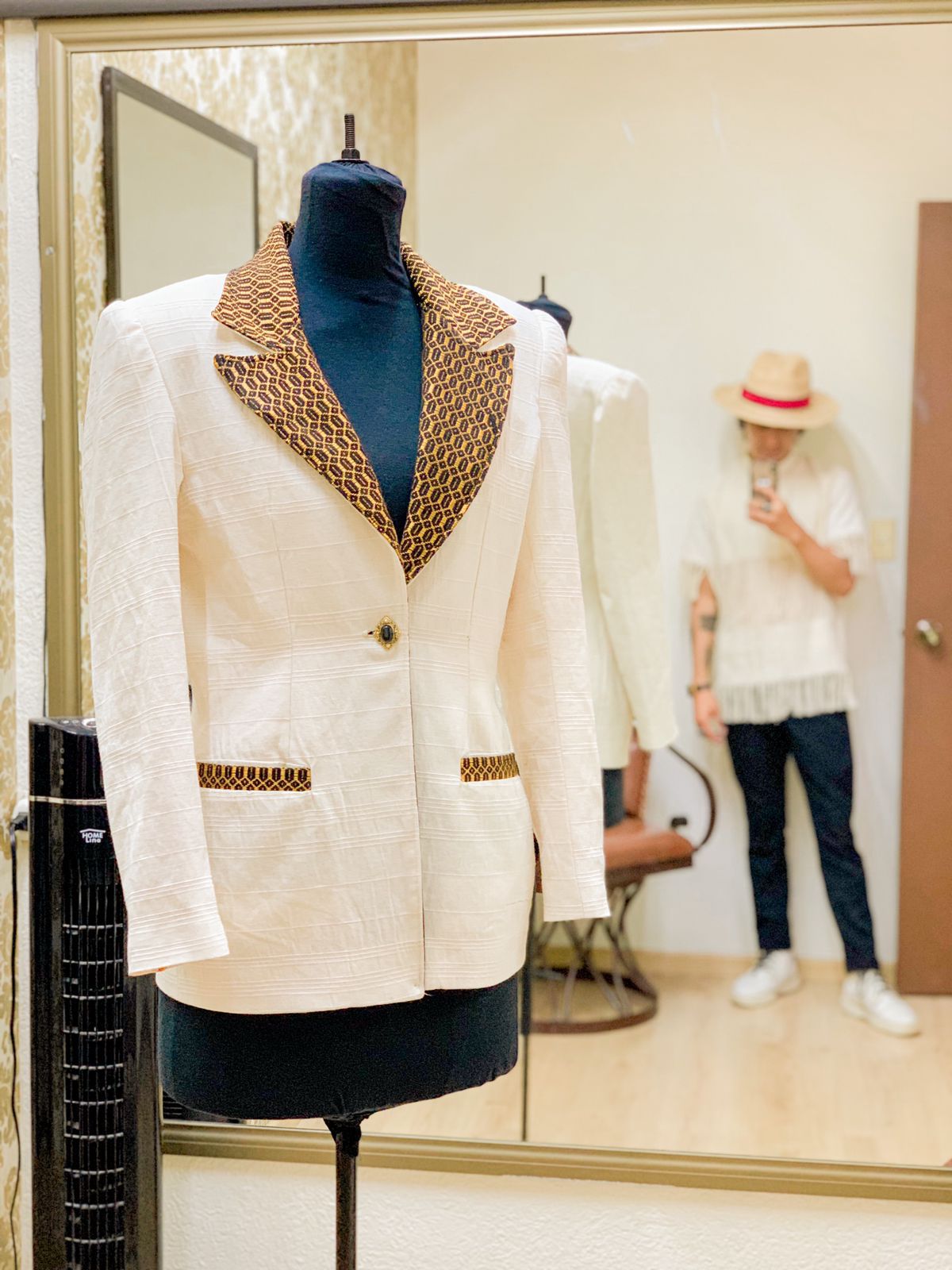 Saco blanco con cuello bordado en dorado sobre maniquí